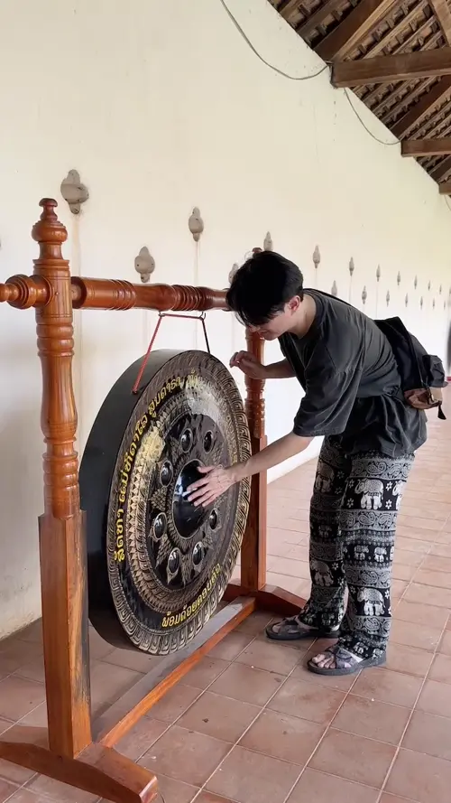 사원에서 복을 기원하며 종을 쓰다듬는 친구