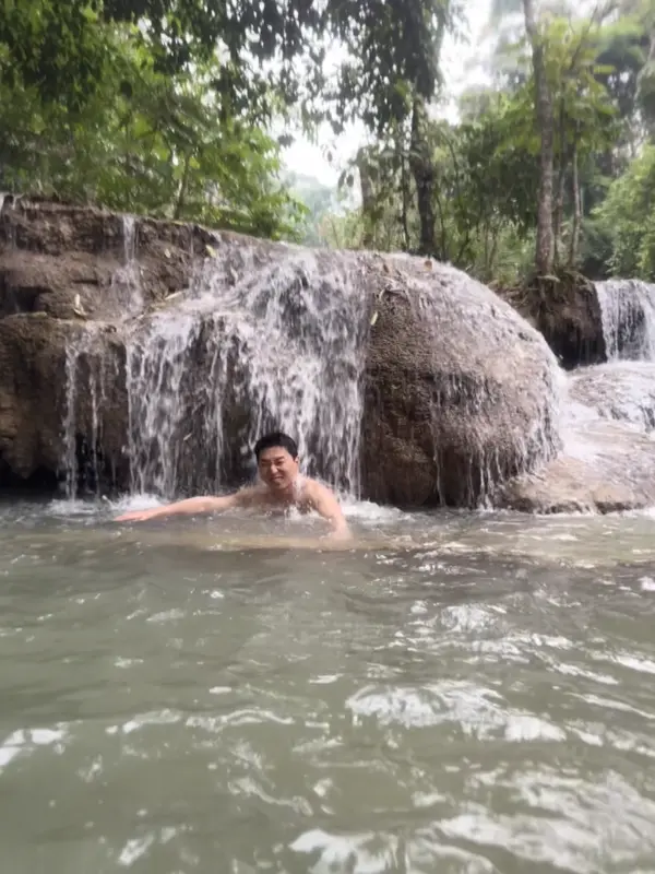 꽝시 폭포에서 사진 찍는 자세를 잡는 친구