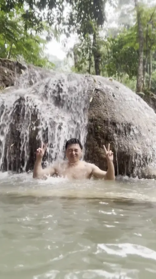 꽝시 폭포에서 사진 찍는 자세를 잡는 친구