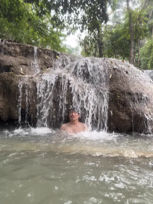 꽝시 폭포에서 사진 찍는 자세를 잡는 친구