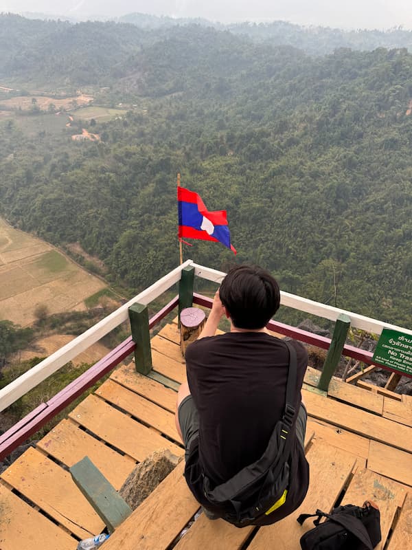 Friend taking a picture of  the Laos flag on the Namxay viewpoint
