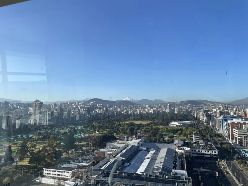 창문 너머 구름 한 점 없는 날씨에 또렷한 코토팍시 화산