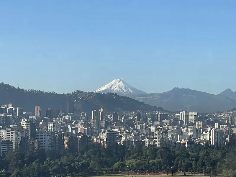 창문 너머 구름 한 점 없는 날씨에 또렷한 코토팍시 화산